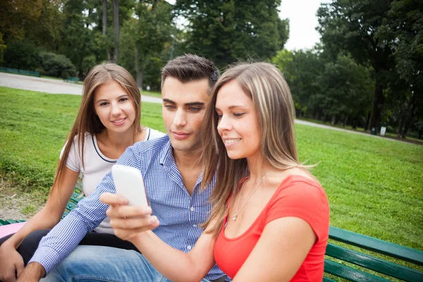 Vänner tittar på en smartphone — Stockfoto