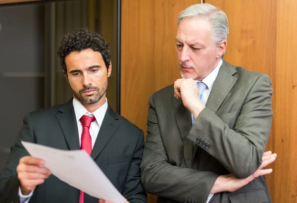 Businessman showing a document to colleague — Stock fotografie