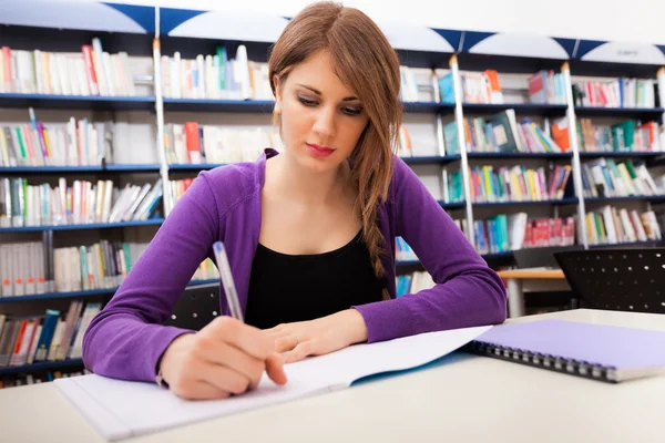 Student schreibt auf Notizbuch — Stockfoto