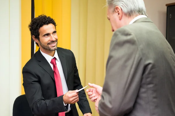 Businessman giving business card to a customer — Φωτογραφία Αρχείου