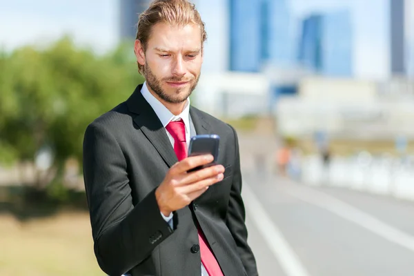 Homem de negócios com telefone móvel na mão — Fotografia de Stock
