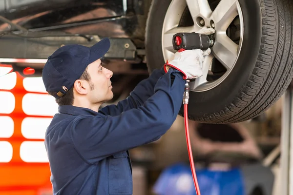 Mechaniker ersetzt ein Rad — Stockfoto