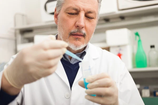 Pesquisador segurando frasco com líquido azul — Fotografia de Stock