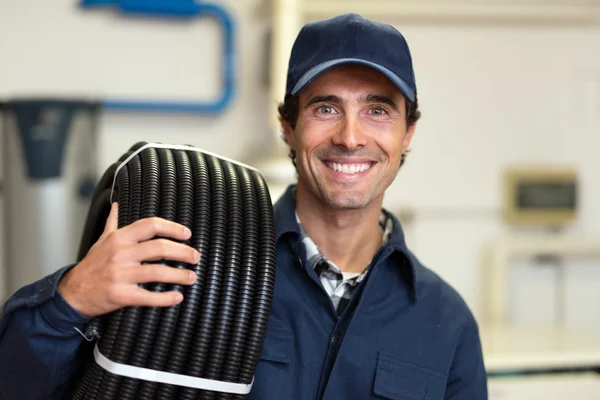 Trabajador que lleva conducto corrugado — Foto de Stock