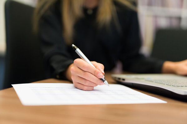 person writing on sheet of paper