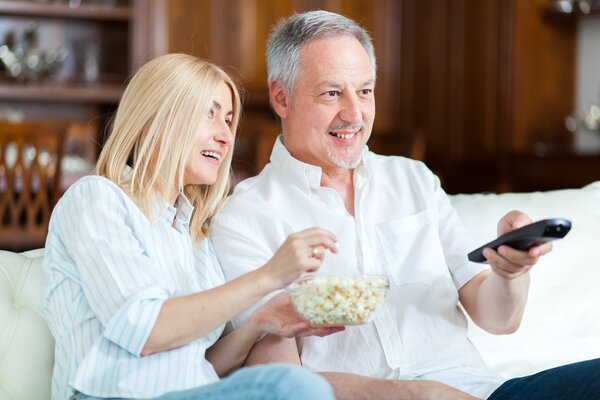 Couple eating pop-corn and watching tv
