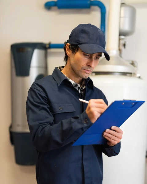 Técnico de fijación de un calentador de agua caliente — Foto de Stock