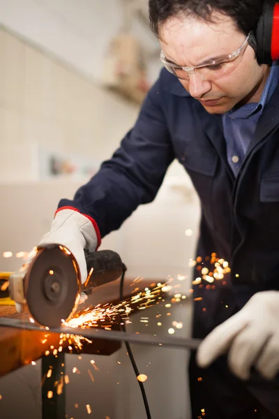 Worker grinding a metal plate — Stock Photo, Image