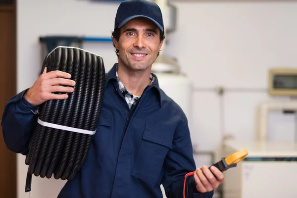 Trabajador que lleva conducto corrugado y probador — Foto de Stock