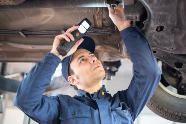 Mecánico usando una luz para inspeccionar — Foto de Stock