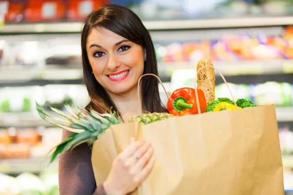 Frau kauft im Supermarkt ein — Stockfoto