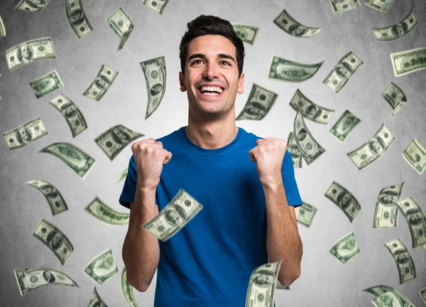 Young man in a rain of money — Stock Photo, Image