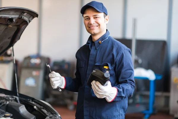 Auto mechanic putting oil in a car engine — Stock Photo, Image