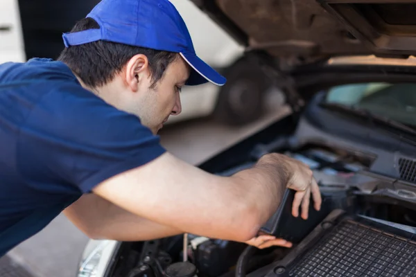 Mechaniker setzt Öl in einen Automotor — Stockfoto