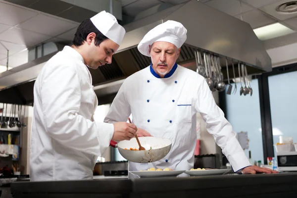 Chefs trabalhando em uma cozinha — Fotografia de Stock