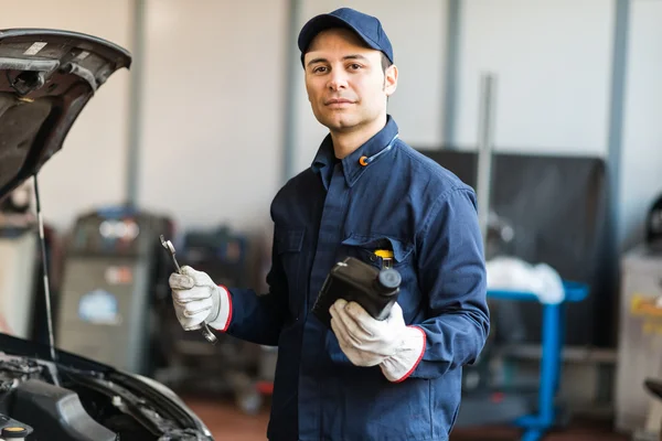 Automechanik, držící džbán motorového oleje — Stock fotografie
