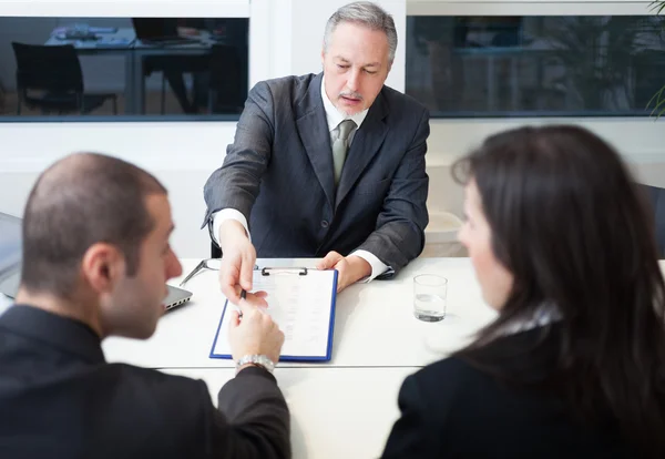 Businessman showing document to couple — Stock Photo, Image