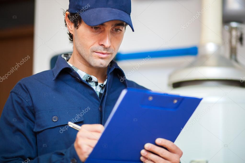Technician fixing an hotwater heater Stock Photo by ©minervastock 96919240
