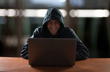 Hacker in front of his computer clipart