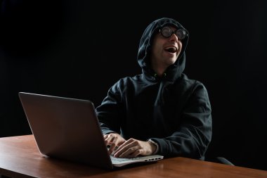 Hacker in front of his computer clipart