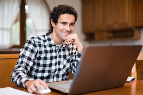 Uomo che usa il suo portatile a casa — Foto Stock