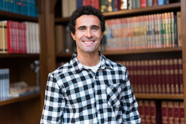 Smiling man in a library — Stock Photo, Image