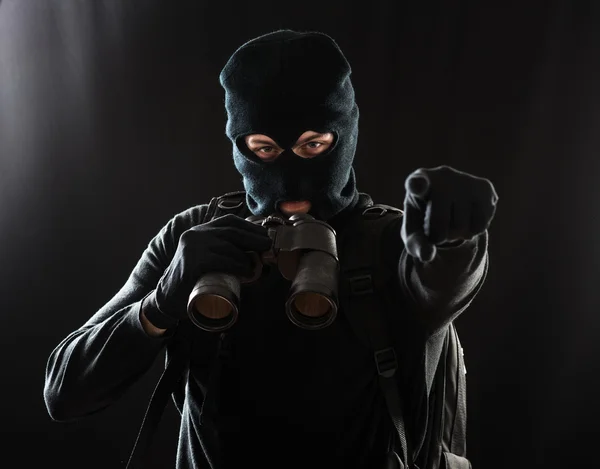 Thief in black clothes using binoculars — Stock Photo, Image