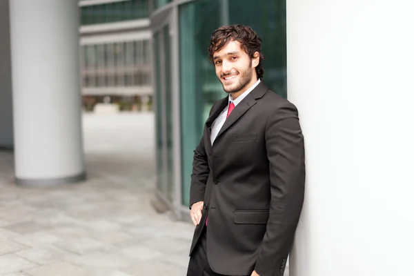 Businessman lying against a wall — Stock Photo, Image