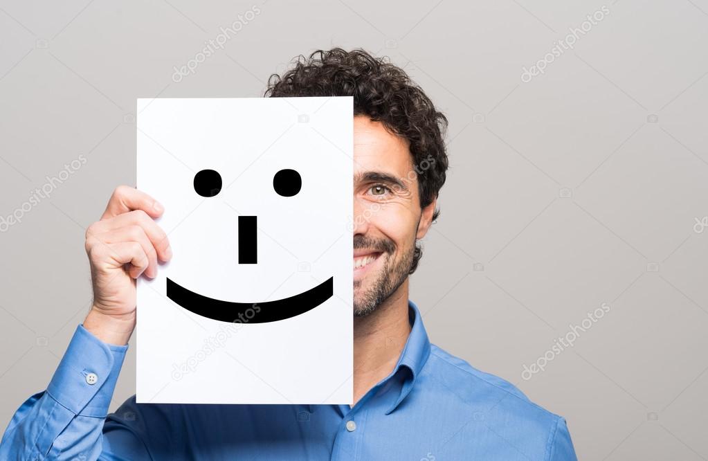 man covering half face with smiling emoticon