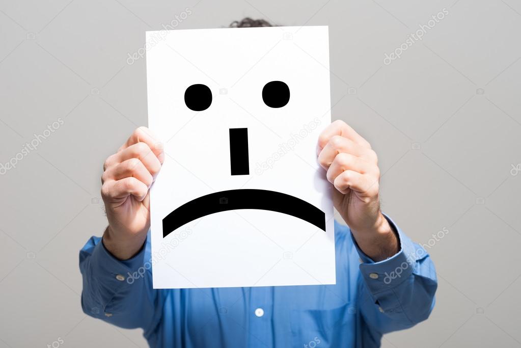 Man holding a sad face