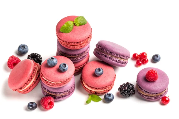 Macarrones coloridos con frutas de bayas sobre fondo blanco — Foto de Stock