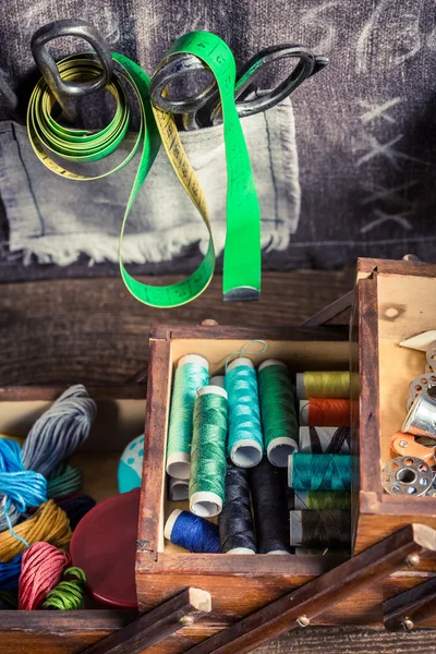 Op maat van houten doos met naalden, draden en knoppen — Stockfoto