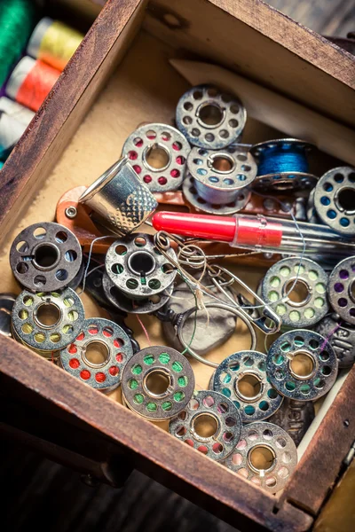Fechar a caixa de madeira do alfaiate com agulhas, fios e botões — Fotografia de Stock