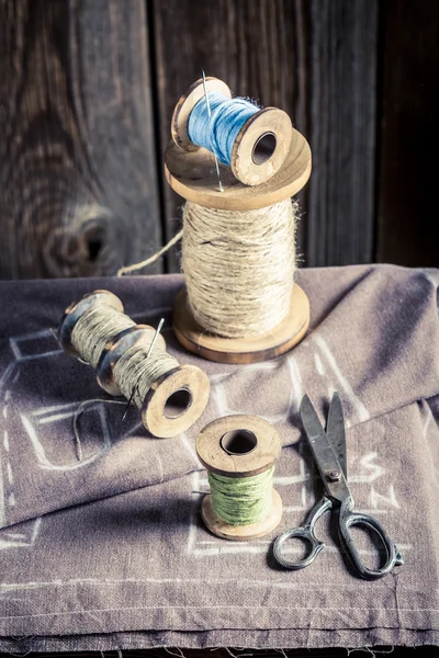 Mesa de costura com agulha, fios e tesoura — Fotografia de Stock