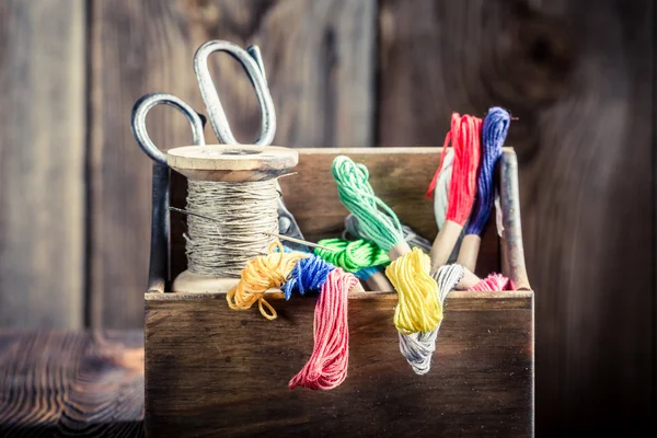 Fils, aiguilles et ciseaux sur table tailleur — Photo