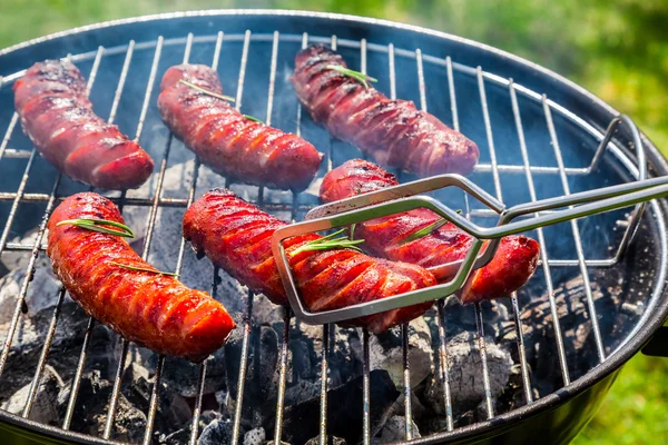 Saucisses rôties aux épices et romarin sur un gril — Photo