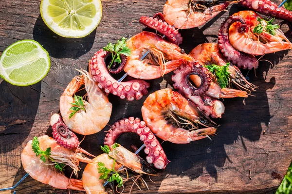 Fresh skewers of seafood with lemon and parsley in garden — Stock Photo, Image