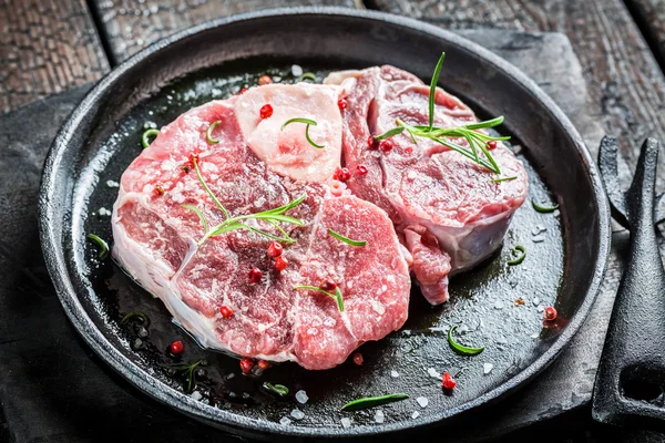 Primer plano de carne roja con romero y pimienta listo para asar a la parrilla — Foto de Stock