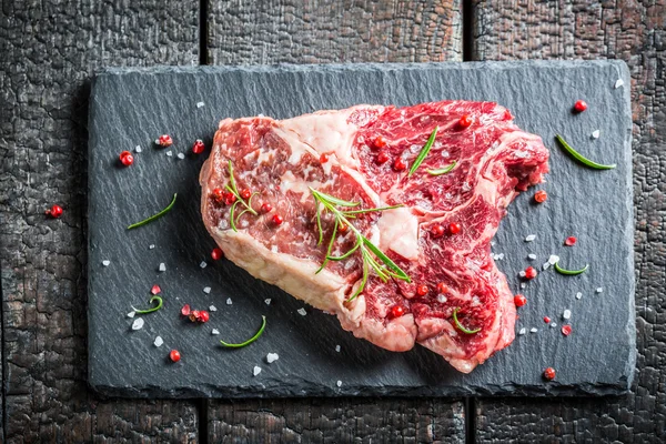 Carne com alecrim e pimenta em uma chapa de pedra — Fotografia de Stock