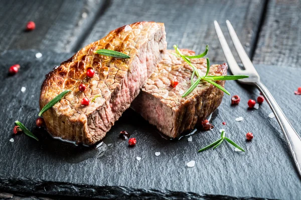 Carne quente grelhada com alecrim fresco na placa — Fotografia de Stock