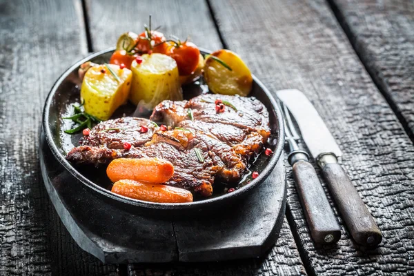 Roasted vegetables and steak with herbs on grill — Stock Photo, Image