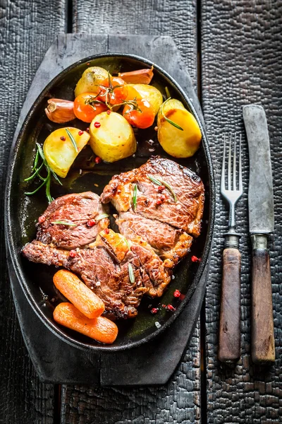 Roasted steak and vegetables with fresh herbs on barbecue dish — Stock Photo, Image