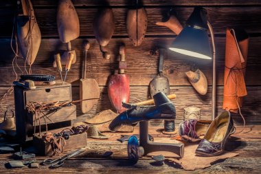 Vintage shoemaker workplace with brush and shoes clipart