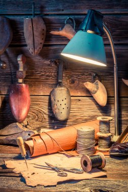 Vintage cobbler workshop with shoes, laces and tools clipart