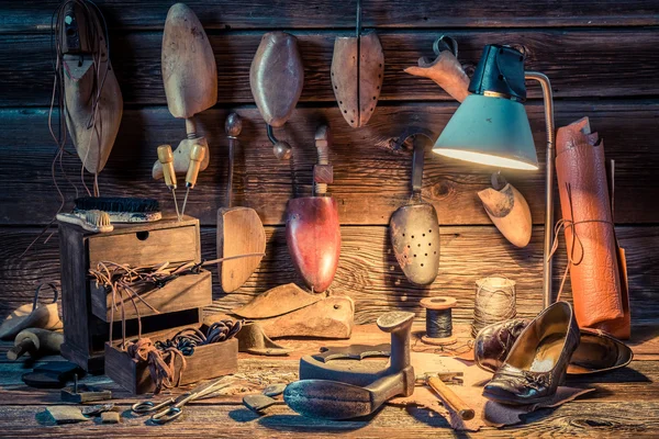 Taller zapatero con herramientas, zapatos y cordones — Foto de Stock