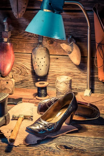 Обувной цех с инструментами, кожей и обувью — стоковое фото