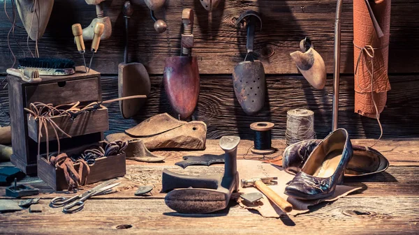 Сапожная мастерская с обувью, лаками и инструментами — стоковое фото