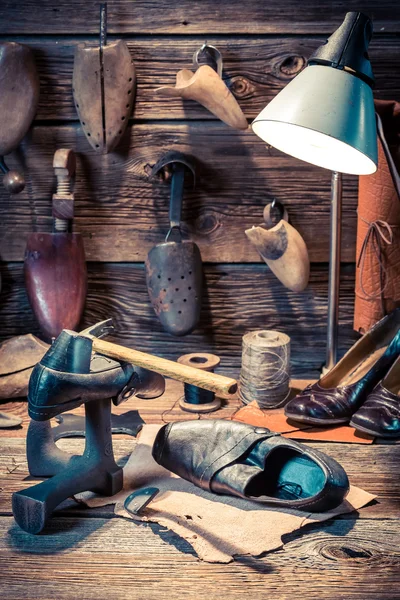 Oficina de sapateiro vintage com ferramentas, sapatos e cadarços — Fotografia de Stock