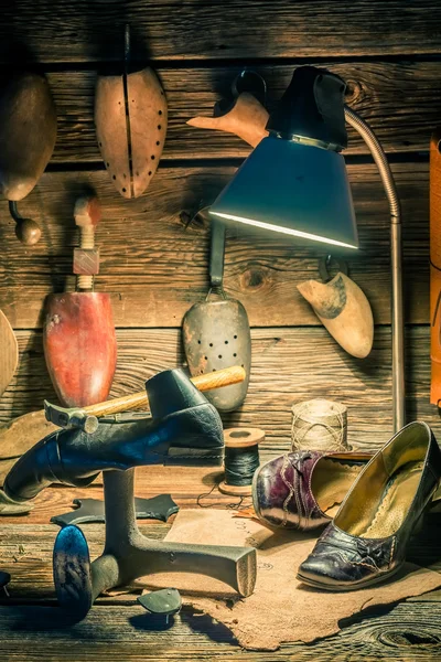 Vintage švec pracoviště s boty, tkaničky a nástrojů — Stock fotografie