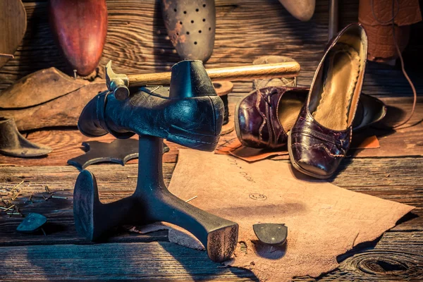 Vintage-Schuhmacher-Arbeitsplatz mit Werkzeug, Leder und Schuhen — Stockfoto